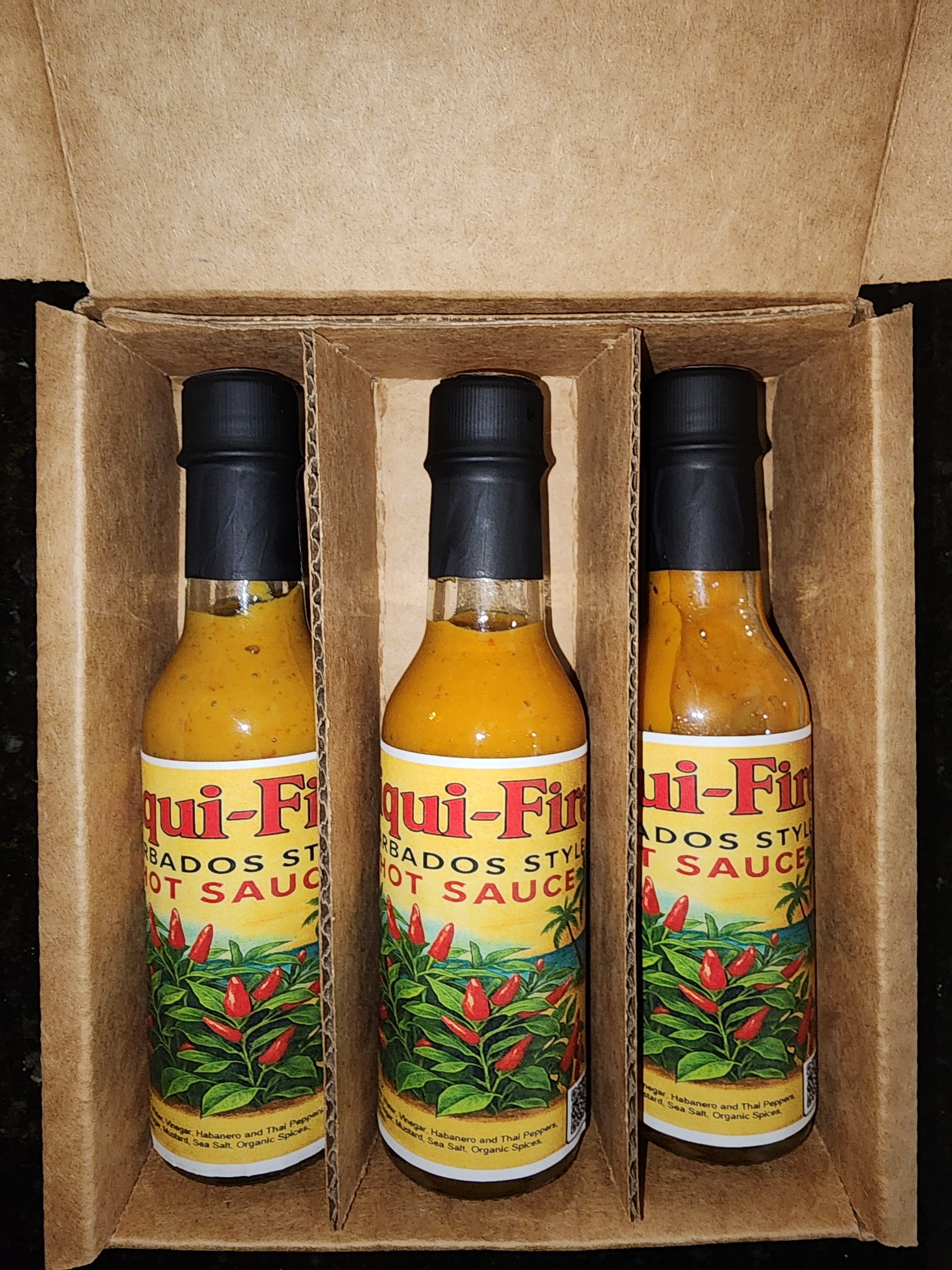 Three bottles of Liqui-Fire Hot Sauce in a box
